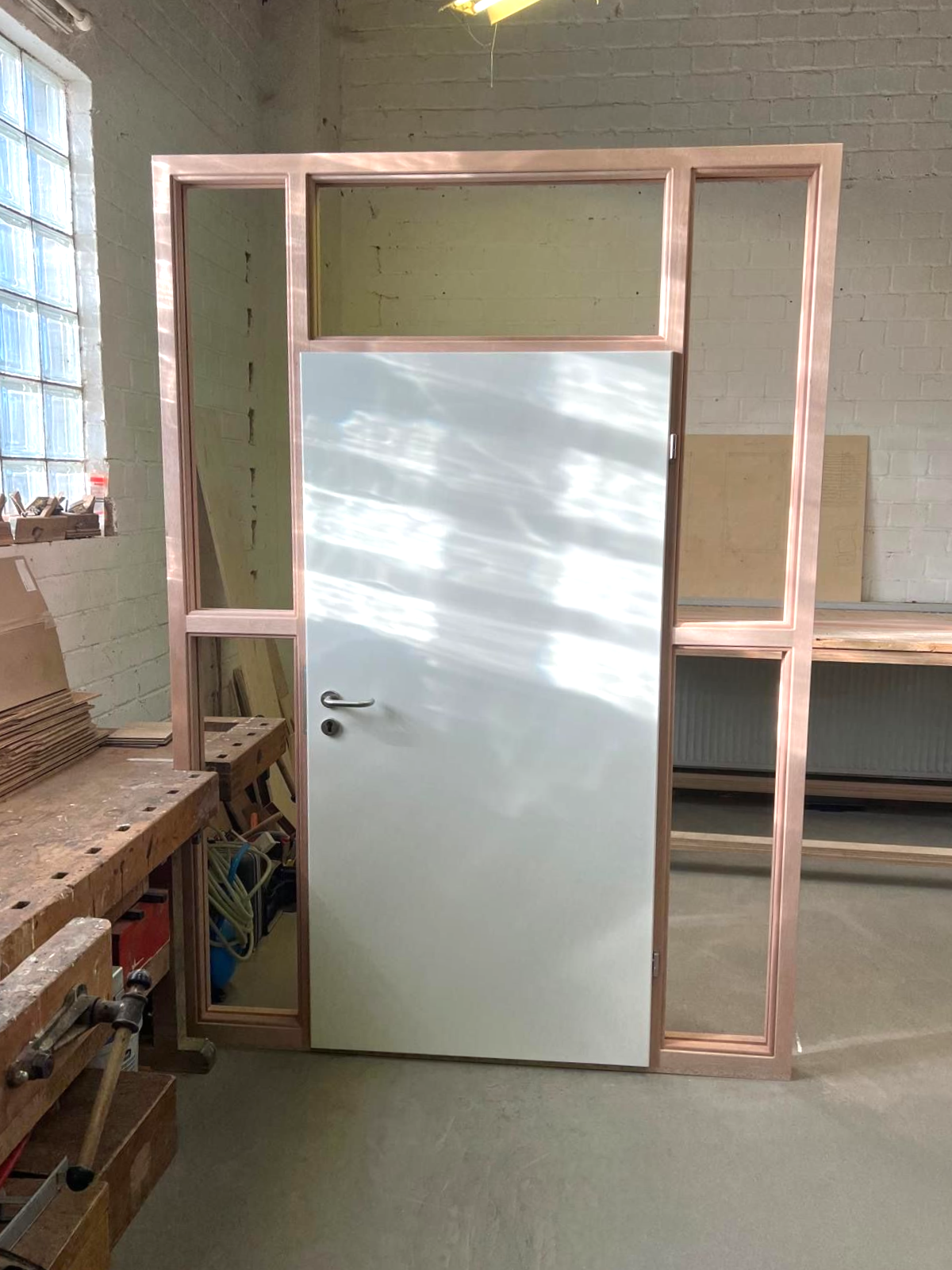 Türrahmen mit weißer Tür, in einer Werkstatt.