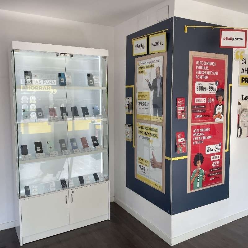 Un rincón de una tienda con una vitrina de cristal llena de teléfonos móviles.