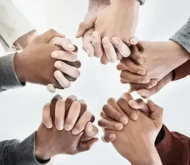 A group of people are holding hands in a circle