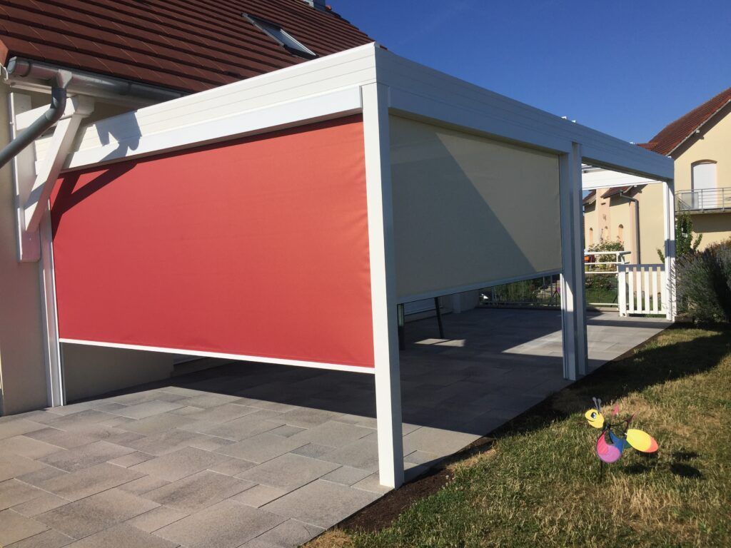 Store rouge baissé d'une pergola blanche