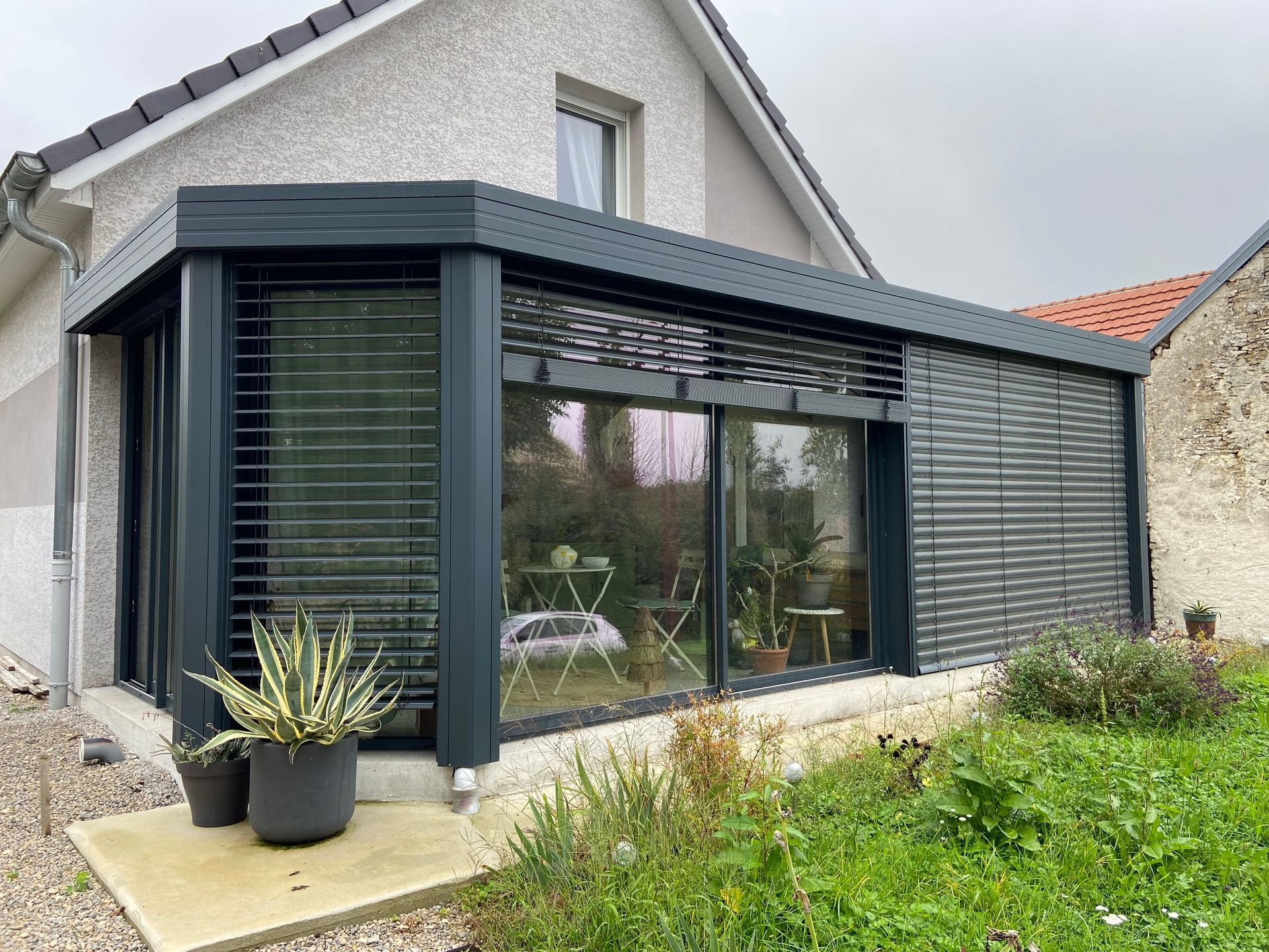 Véranda noire d'une maison sur un niveau vue de l'extérieur