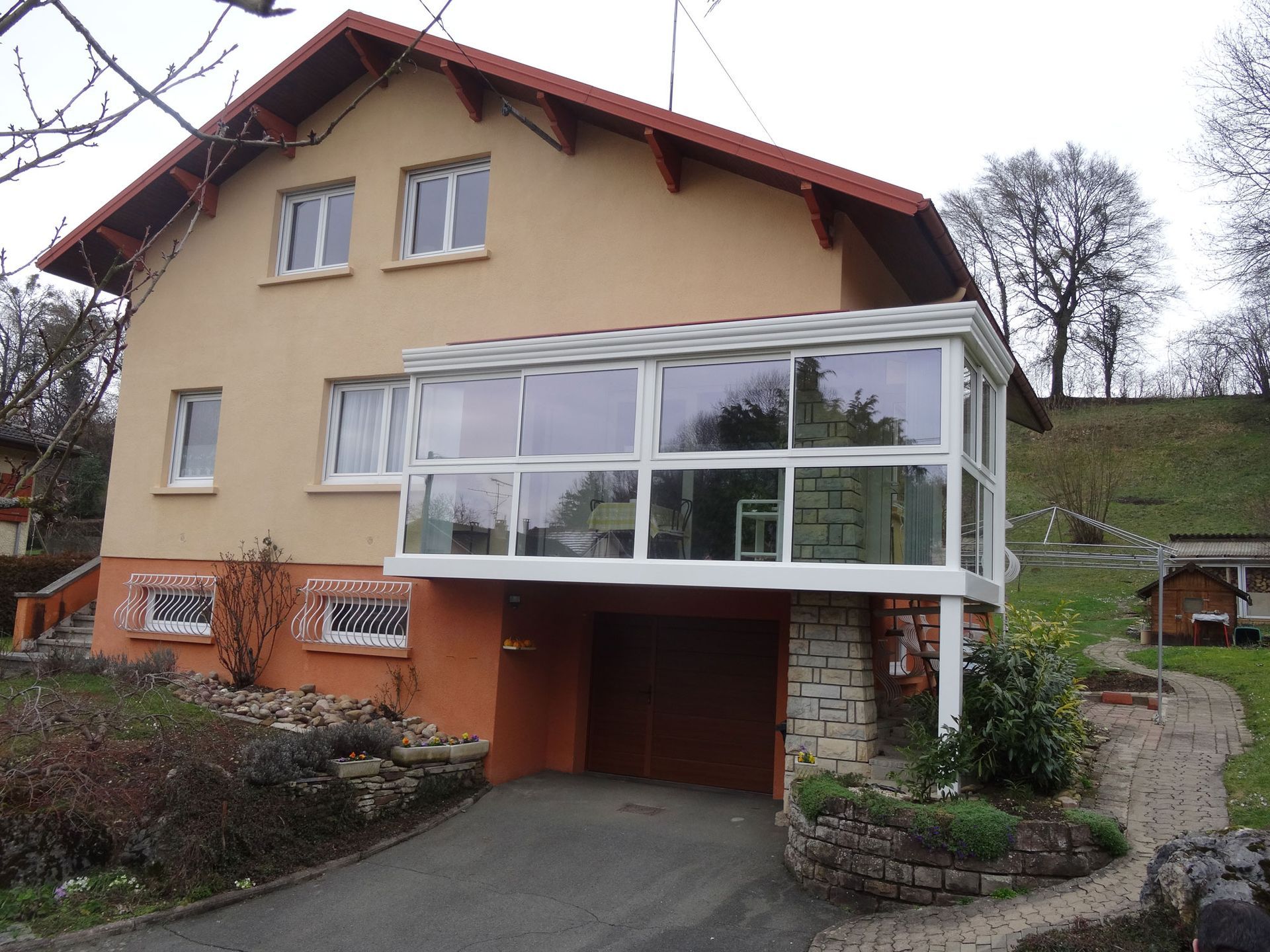 Véranda blanche placée au-dessus de l'entrée d'un garage