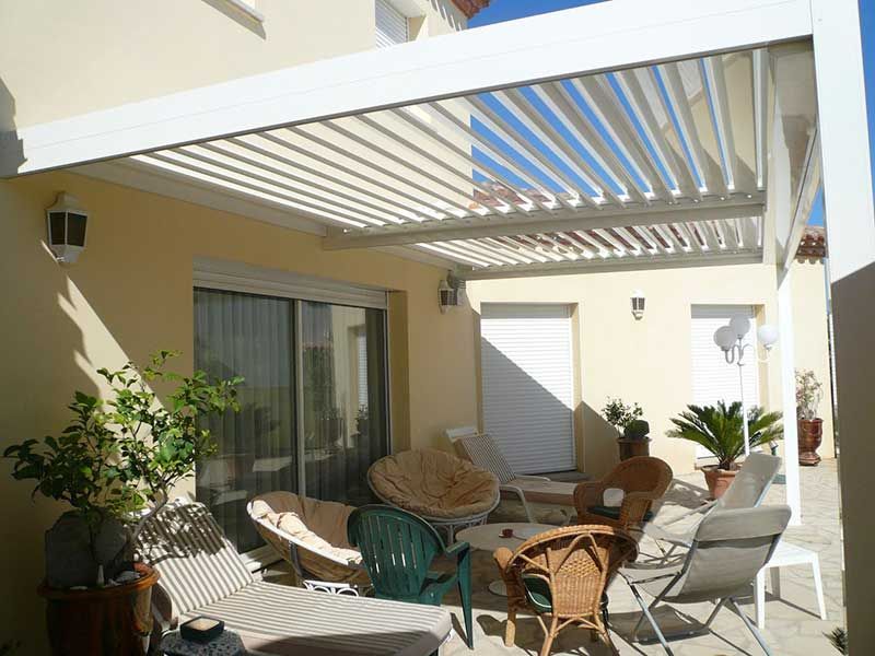 Pergola blanche au-dessus d'un salon de jardin