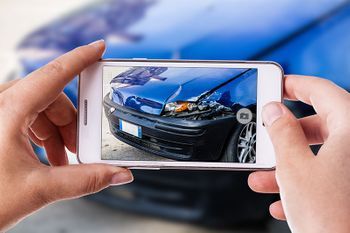 Abbildung: Blaues Auto fotografiert mit Smartphone.