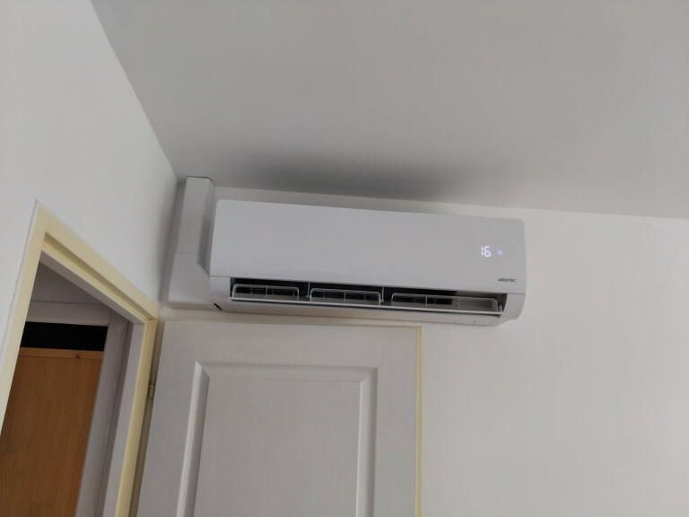 Climatiseur réversible blanc au-dessus d'une fenêtre