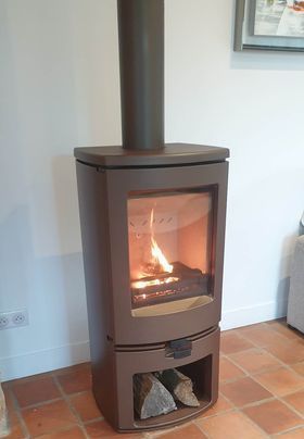 Poêle à bois sur carrelage avec range bûches intégré