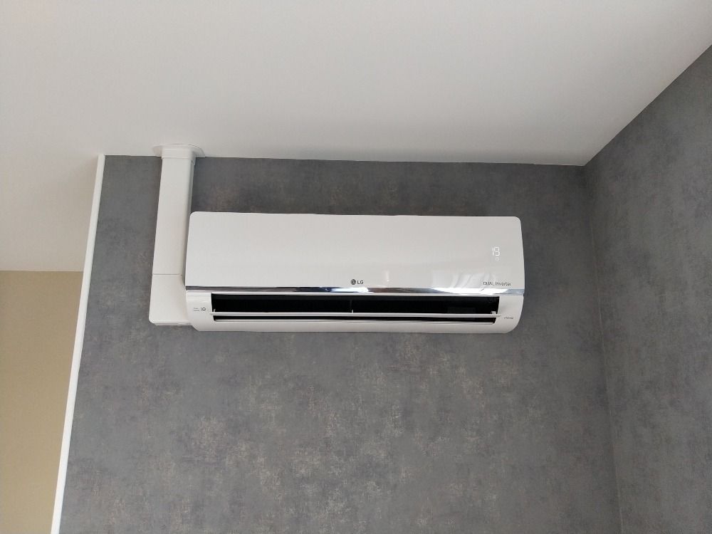 Climatiseur réversible blanc au-dessus d'une fenêtre