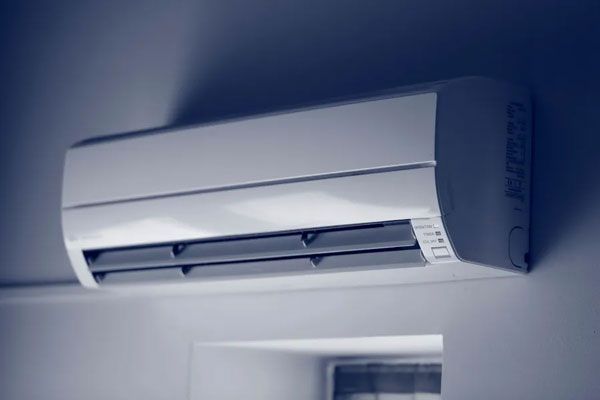 Climatiseur réversible blanc au dessus d'une fenêtre