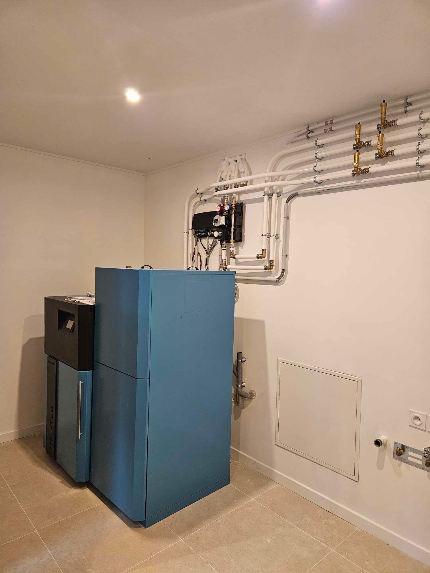 Un réfrigérateur bleu posé dans une pièce à côté d'un mur blanc.