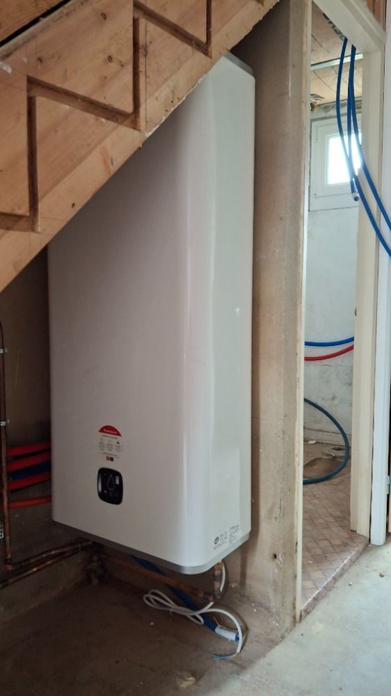 Chauffe-eau blanc sous un escalier