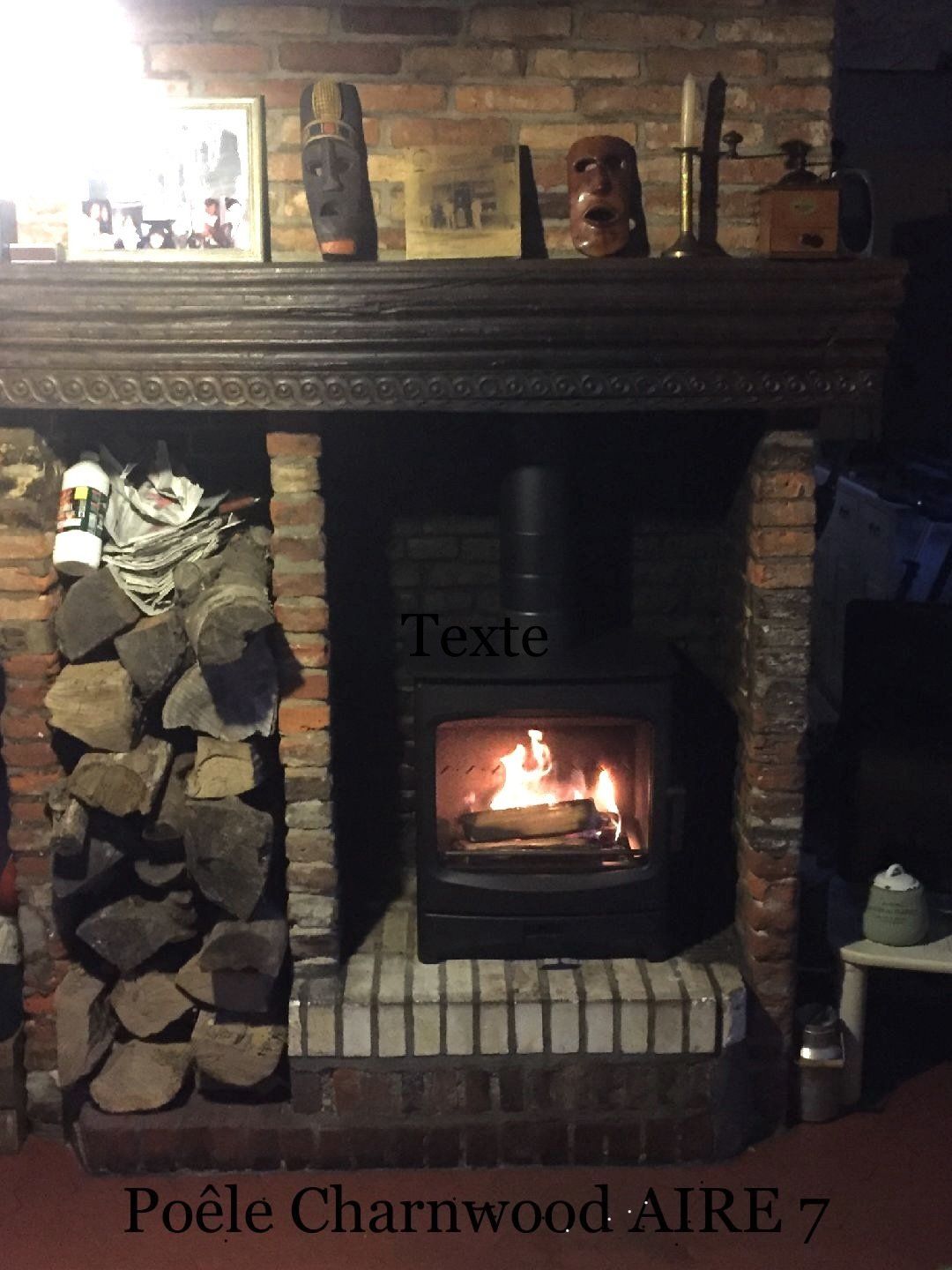 Poêle à bois en fonctionnement placé dans une ancienne cheminée