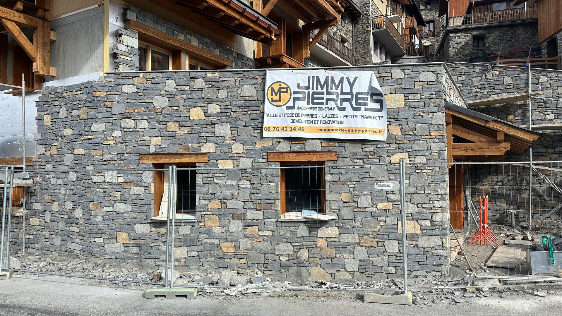 Construction mur en pierre avec affiche Jimmy Pierres