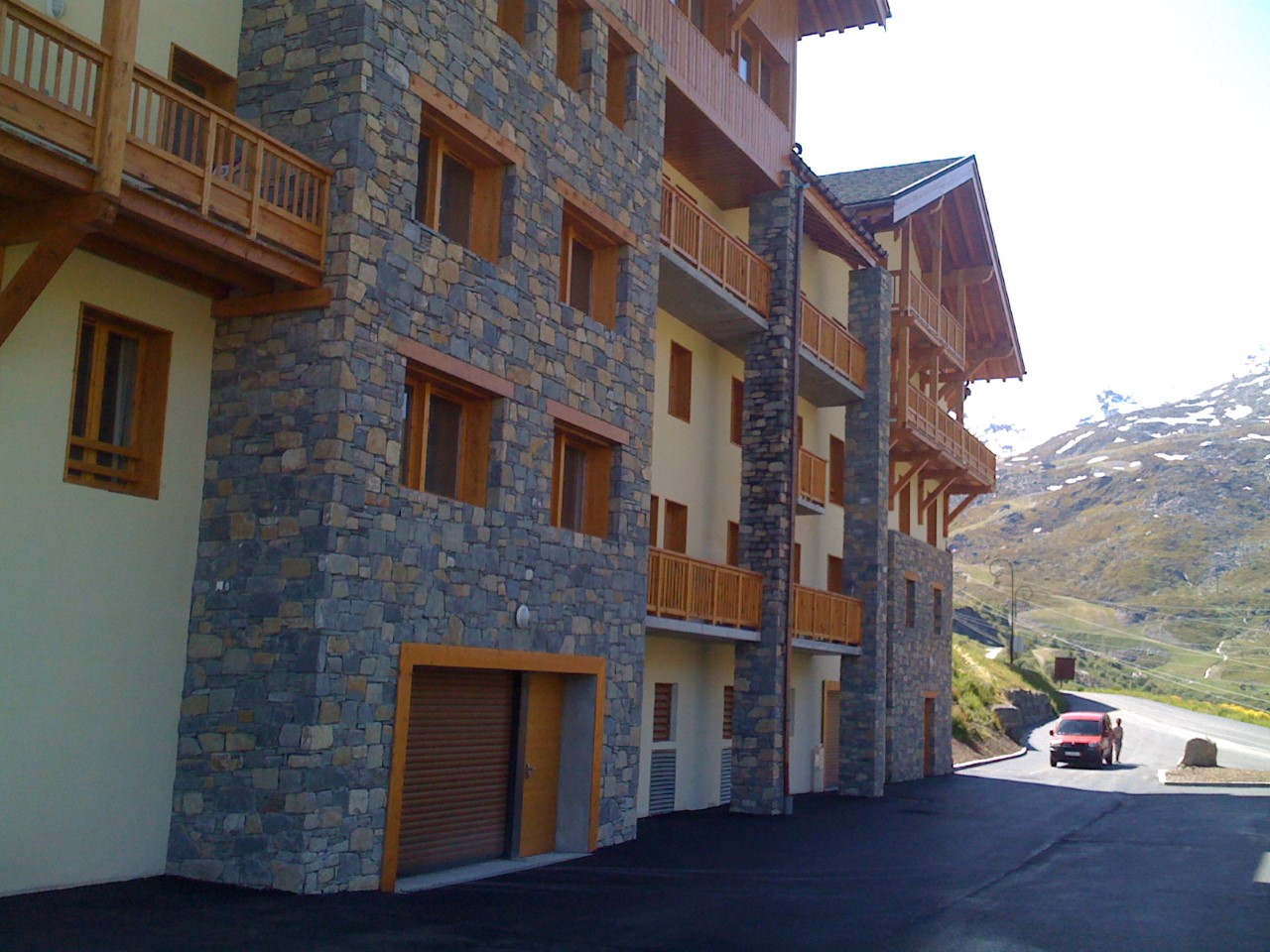 Bâtiment de montage avec devanture en pierre et balcon bois