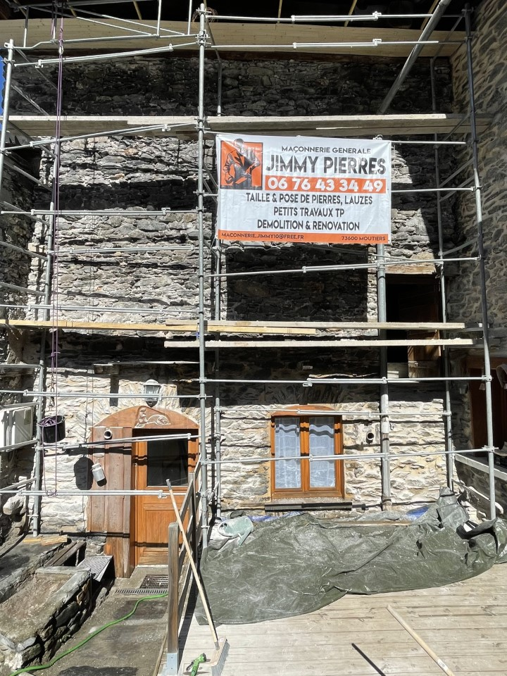 Échafaudage devant une maison en pierre
