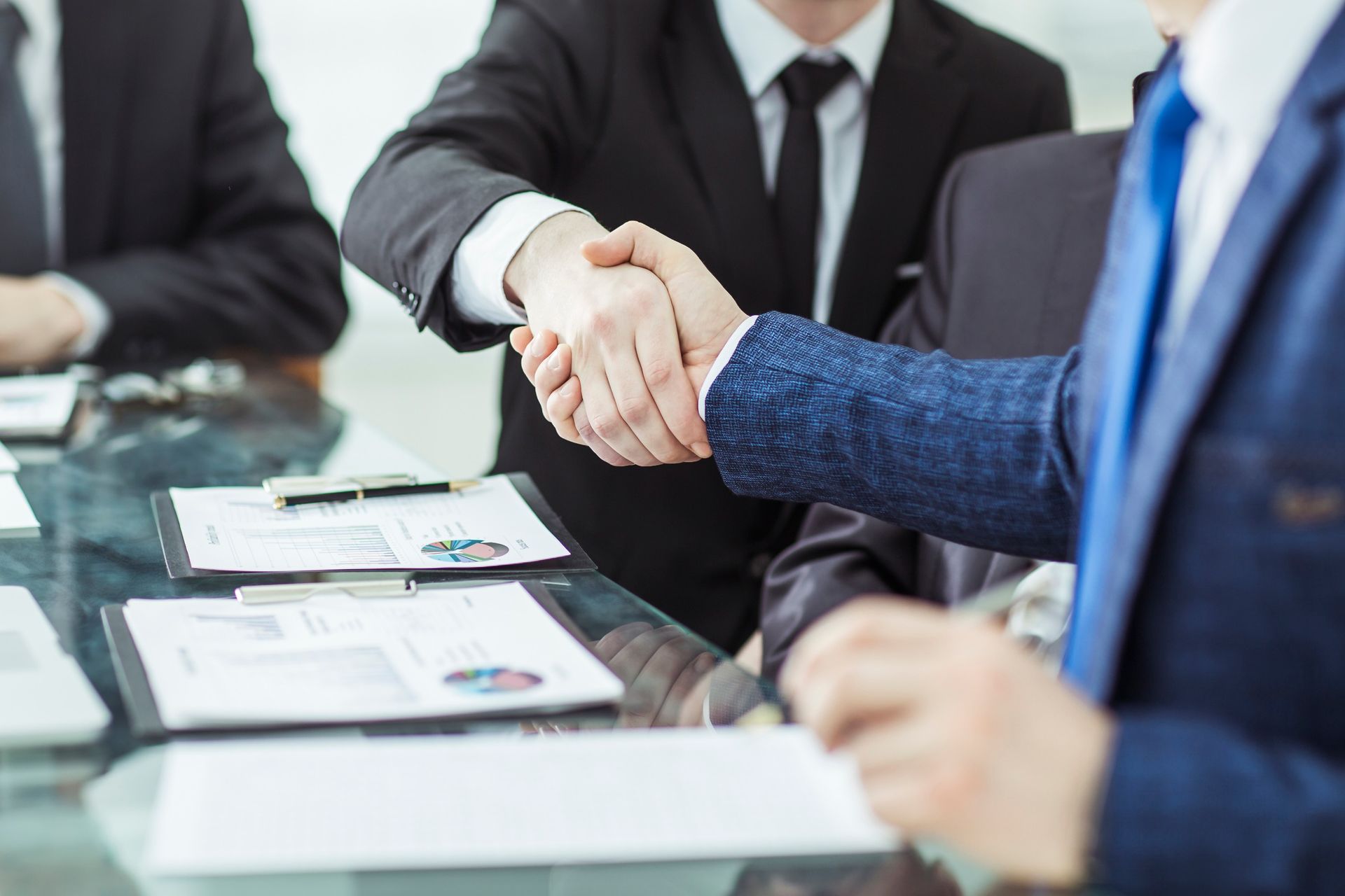 Un grupo de hombres de negocios se dan la mano en una mesa.