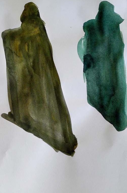 Dos trozos de pintura verde sobre una superficie blanca