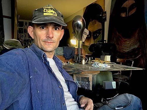 Un hombre que lleva un sombrero está sentado delante de una mesa.