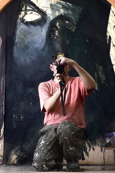 Un hombre se está tomando una foto delante de un cuadro grande.