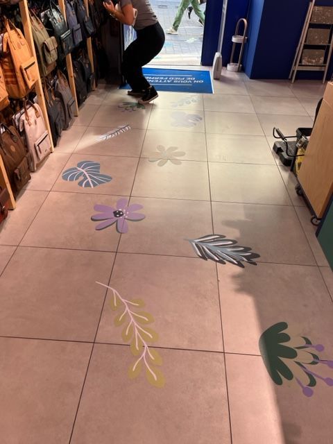Allée de magasin recouverte d'autocollants colorés représentant des fleurs et des feuilles.