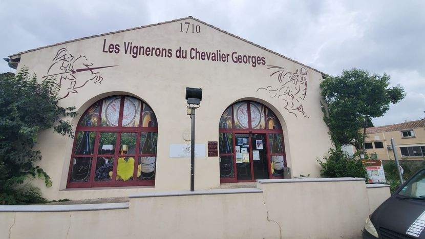 Façade avec fenêtres cintrées et rue bordée d'arbres.