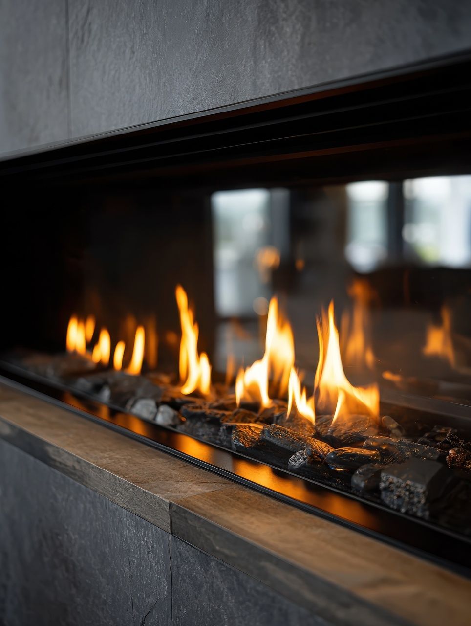 Cheminée aux flammes vacillantes et pierres sombres, dans un cadre moderne.