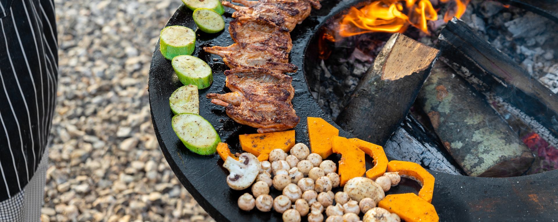 Viandes et légumes grillés sur une grille de brasero.