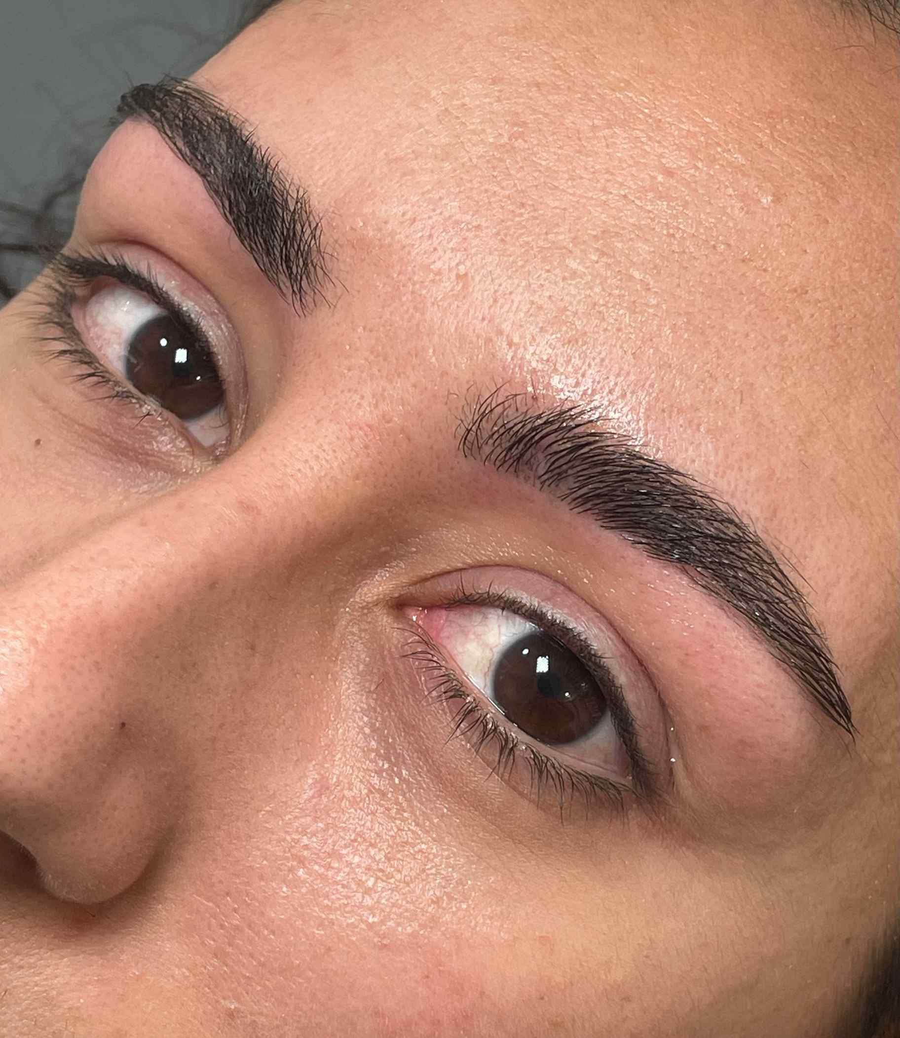 Un primer plano del rostro de una mujer con ojos y cejas marrones.