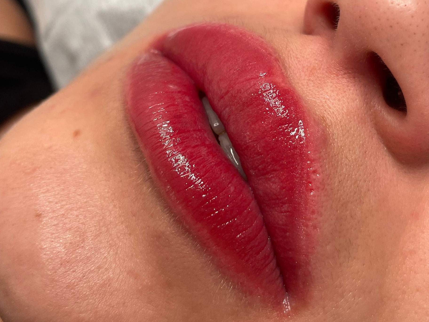 Un primer plano de los labios de una mujer con lápiz labial rojo.