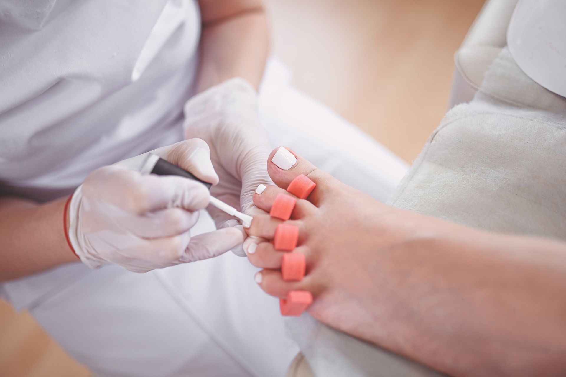 Una mujer se pinta las uñas de los pies en un salón.