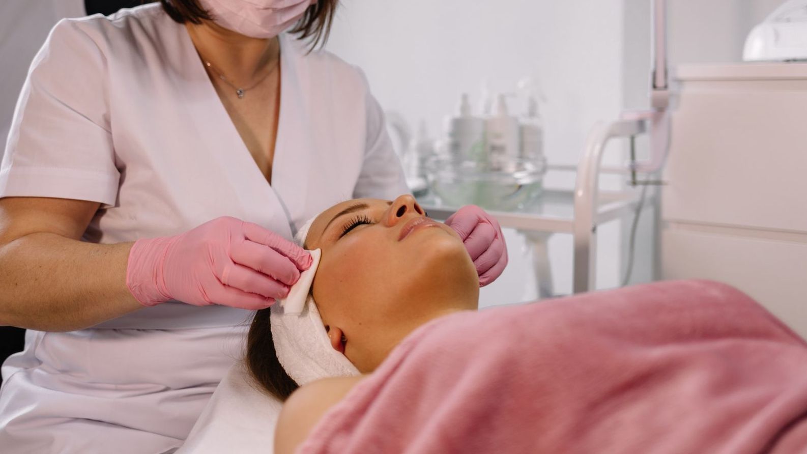 Una mujer recibe un tratamiento facial en un spa. 