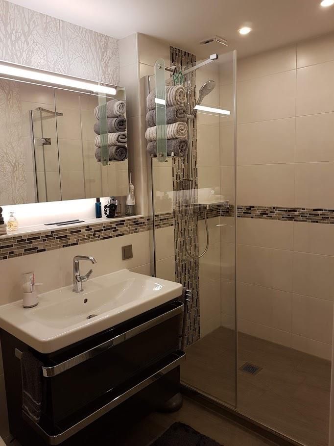 Ein Badezimmer mit Waschbecken, Spiegel und Dusche.