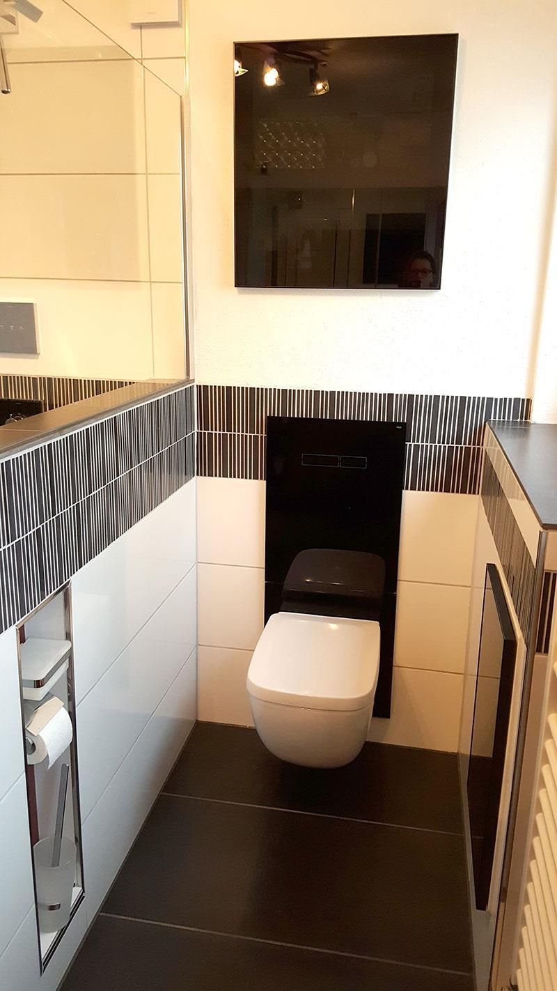 Ein Badezimmer mit Toilette und Spiegel an der Wand.