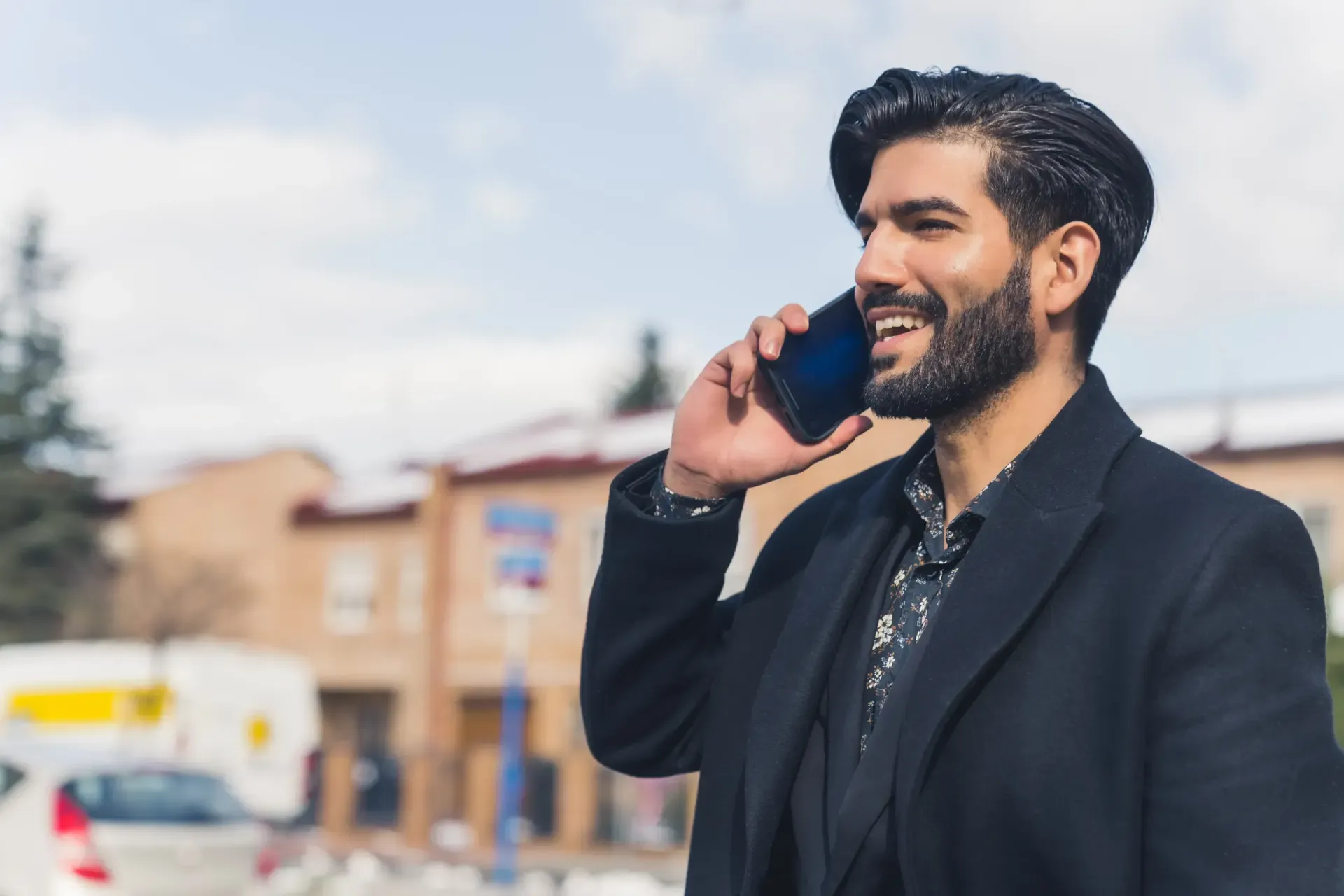 Un hombre feliz al teléfono mientras consulta su visado