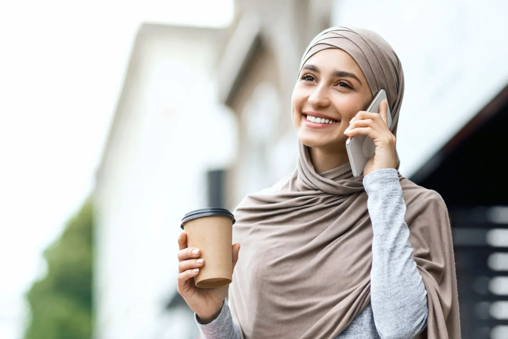 Una mujer musulmana feliz mientras llama por teléfono