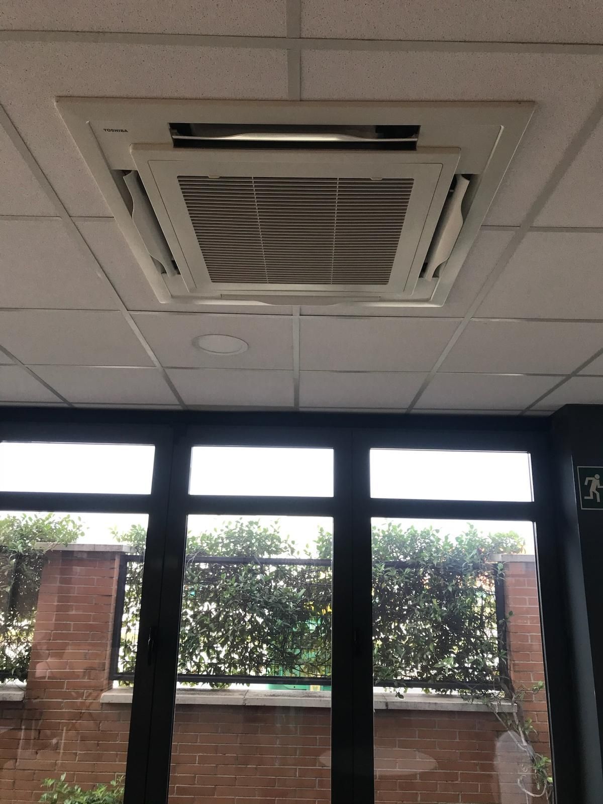 Una habitación con ventilador de techo y muchas ventanas.