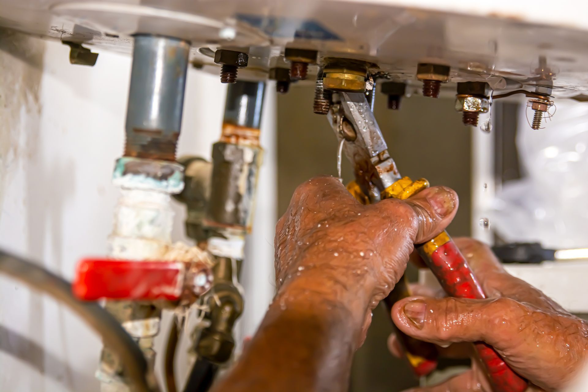 Photo d'un ouvrier qui effectue des réparations sur un chauffe-eau