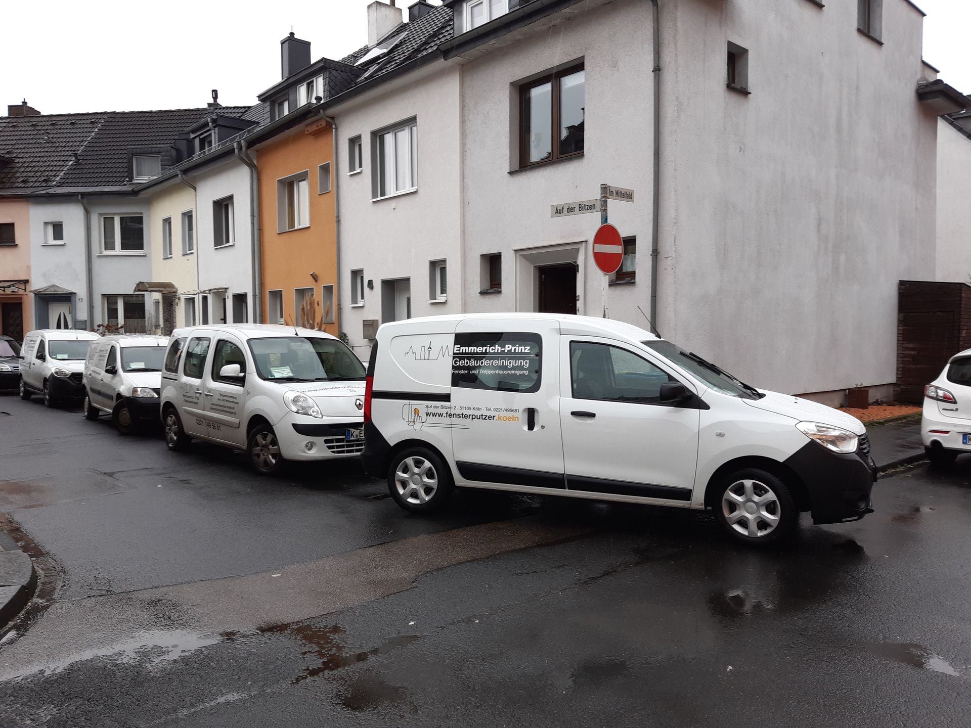 Eine Reihe weißer Lieferwagen parkt vor einem Gebäude