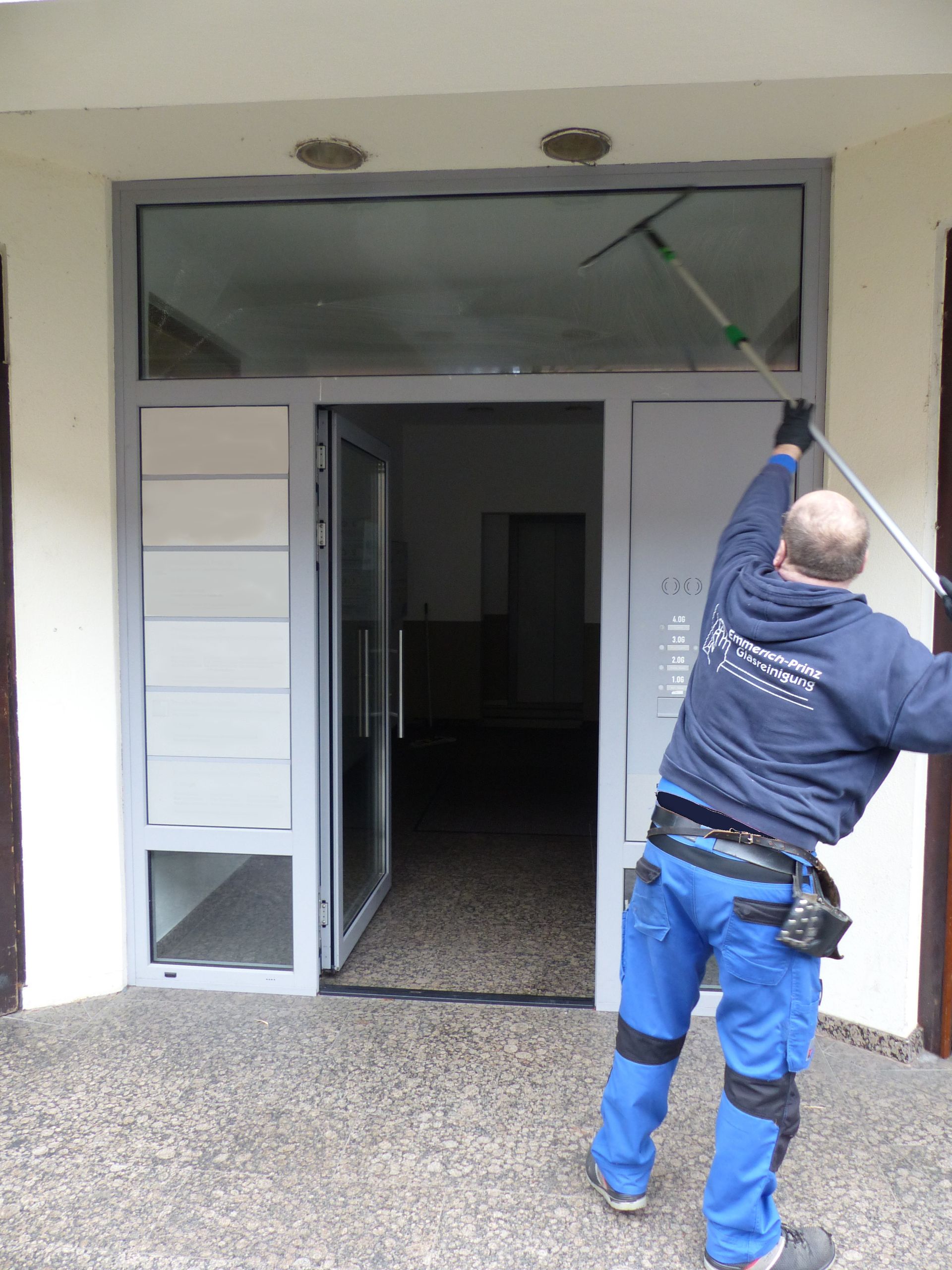 Ein Mann putzt eine Tür mit einer langen Stange