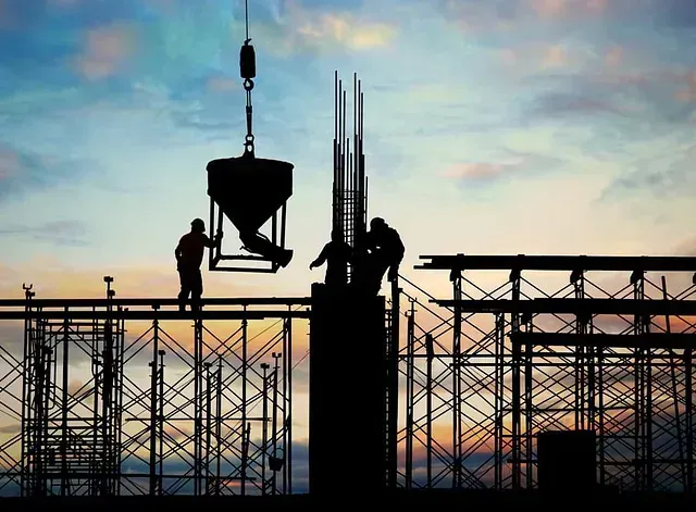 Un grupo de trabajadores de la construcción está parado en la parte superior de un edificio en construcción.