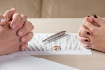 Vertrag, Ehering und gegenüberliegende, gefaltete Hände