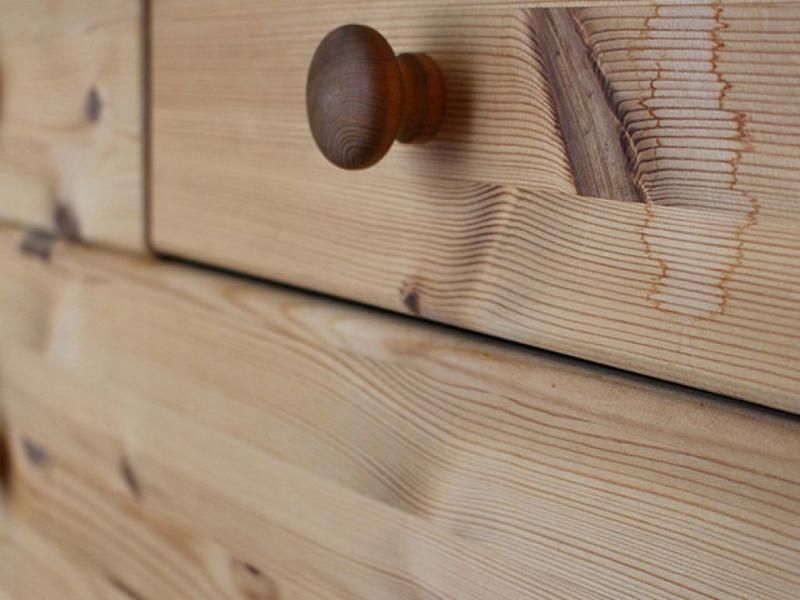 Eine Nahaufnahme einer Holzschublade mit einem Holzgriff.