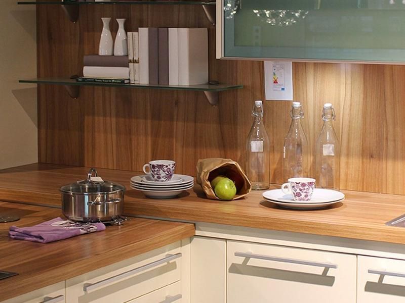 Eine Küche mit einer Holzarbeitsplatte und weißen Schränken