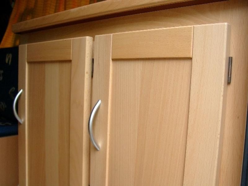 Eine Nahaufnahme eines Holzschranks mit Metallgriffen