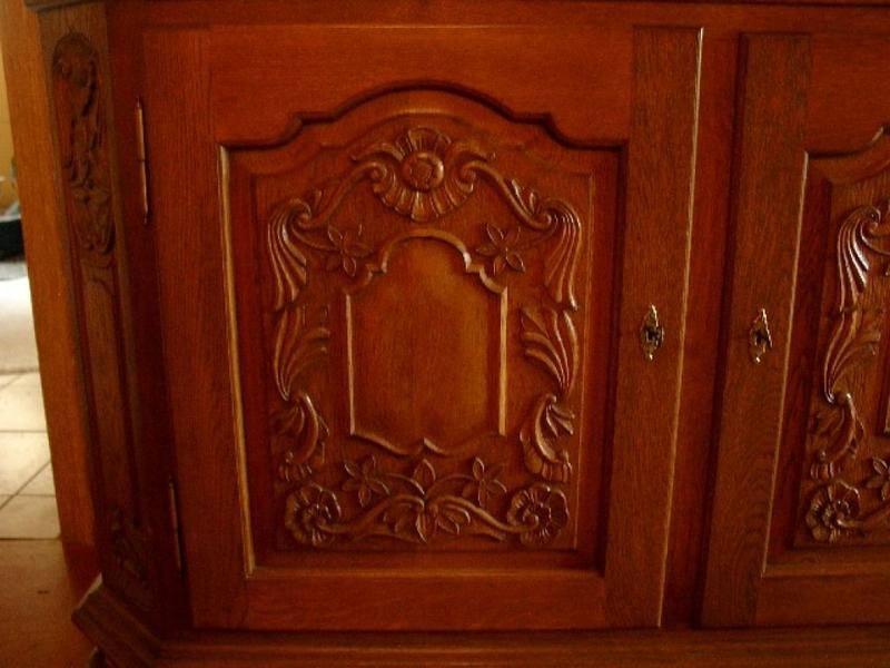 Ein Holzschrank mit einem geschnitzten Muster auf der Tür