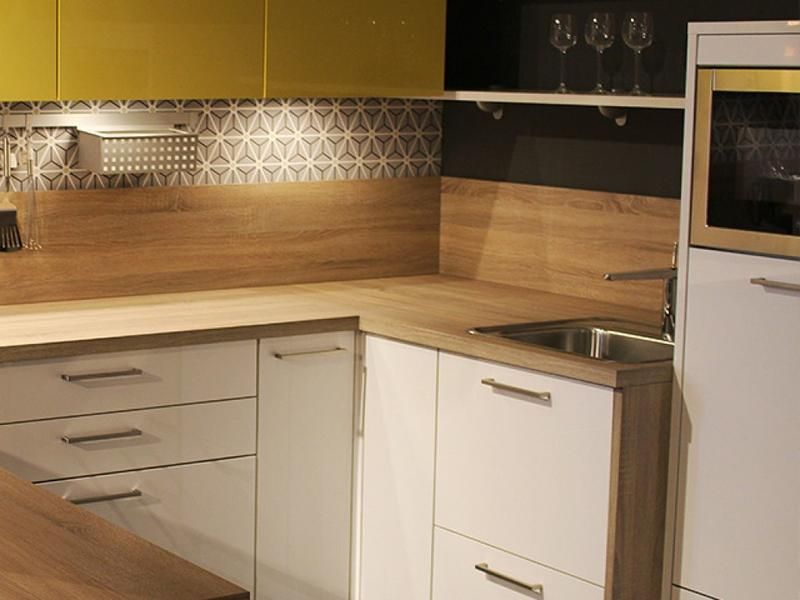 Eine Küche mit weißen Schränken und Holzarbeitsplatten