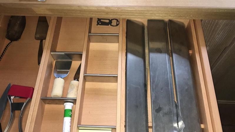 Eine Holzschublade mit Messern und Utensilien darin