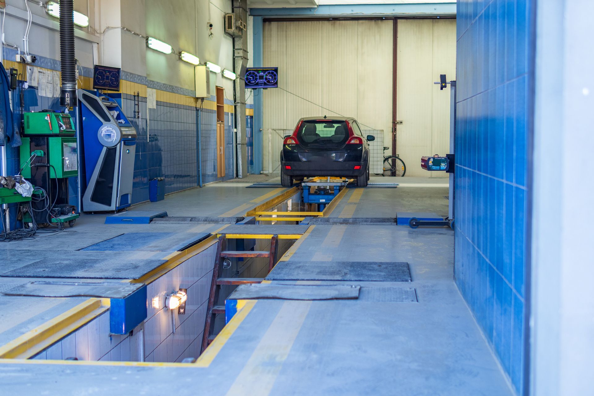 Voiture sur un pont élévateur d'un centre de contrôle technique.