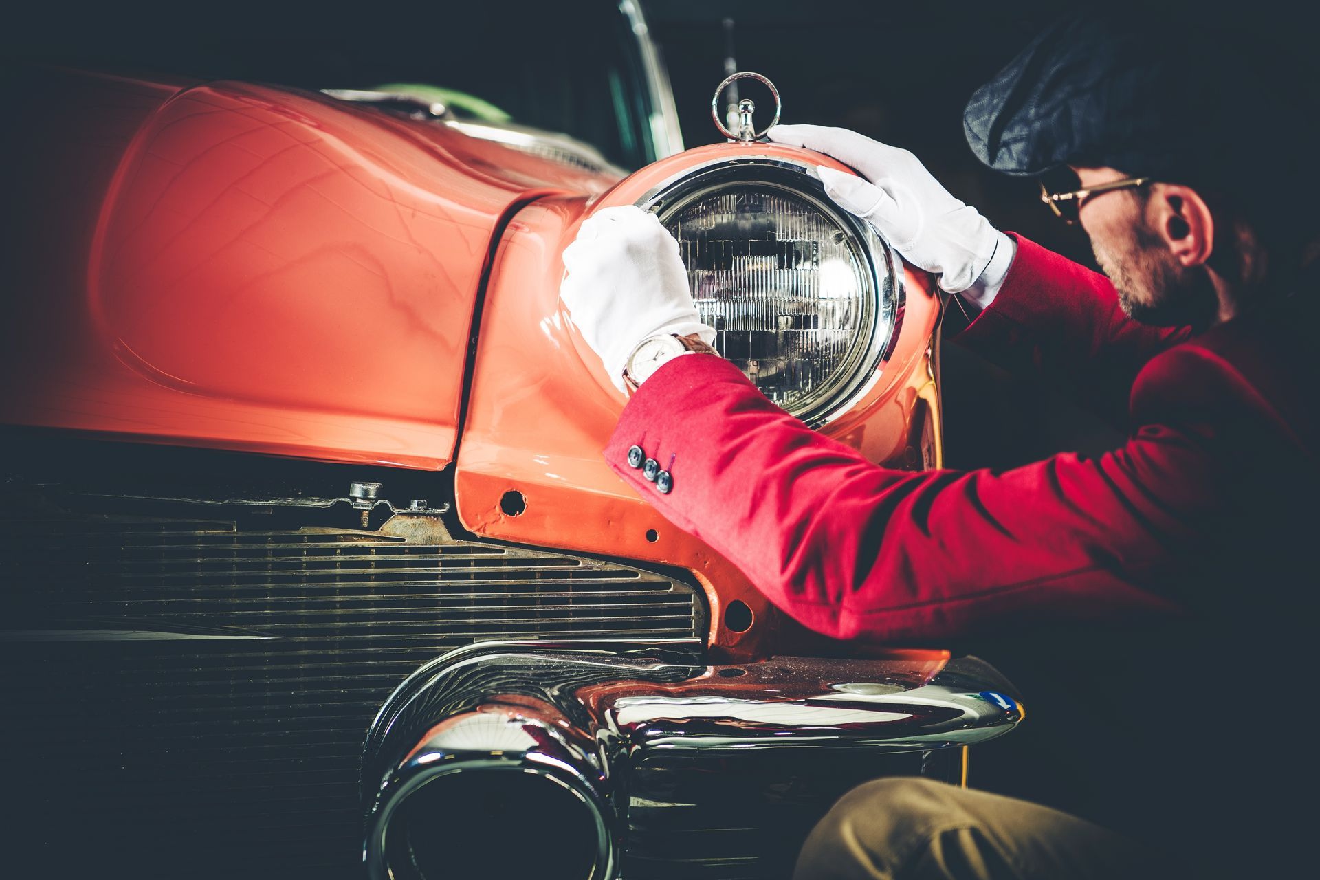 Une personne qui vérifie l'optique d'une voiture ancienne.