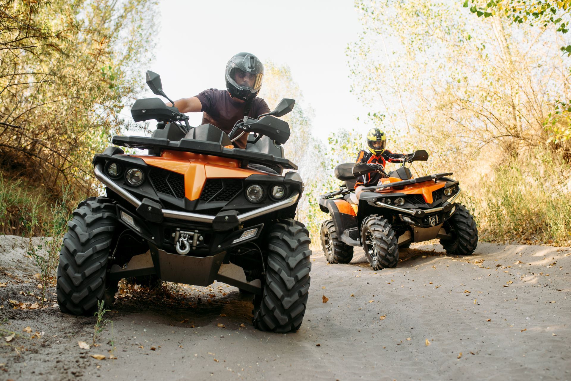 Deux personnes en train de conduire un quad.