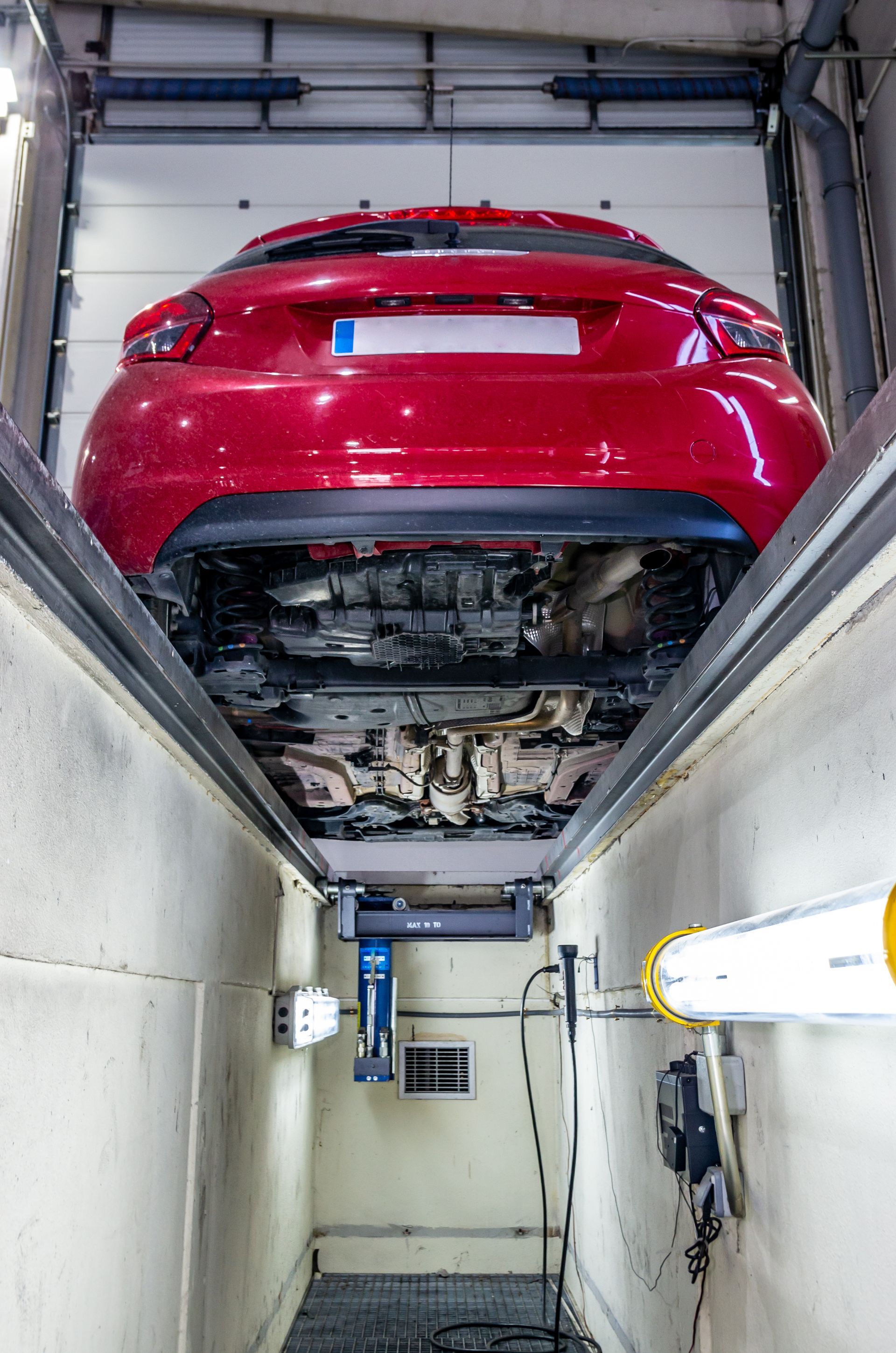 Vue du dessous d'une voiture dans un centre de contrôle technique.